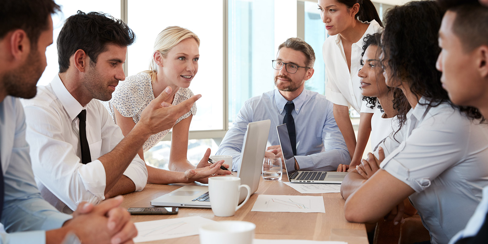 Group Of Businesspeople Meeting Around Table In Office | Bentley Systems | Infrastructure Engineering Software Company Group Of Businesspeople Meeting Around Table In Office